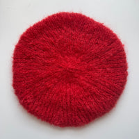 Red textured beret on a white background