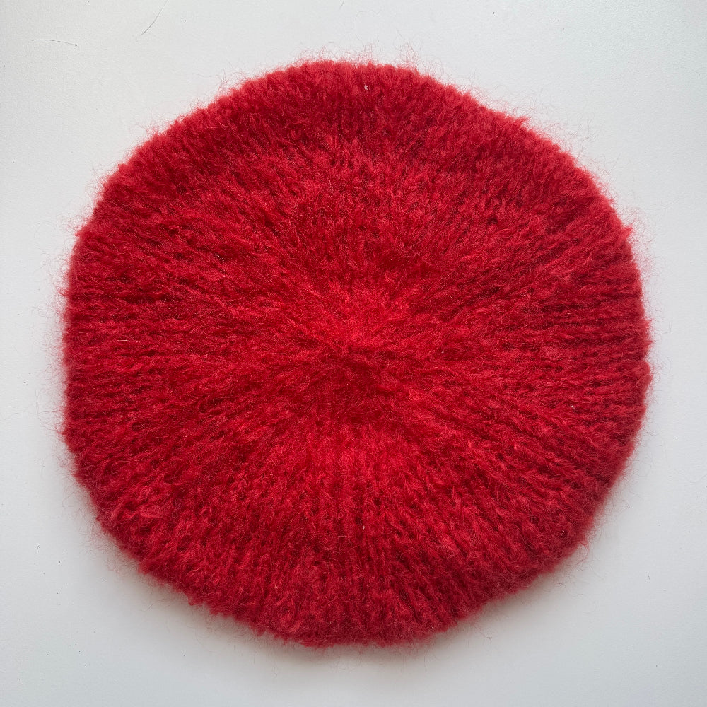 Red textured beret on a white background