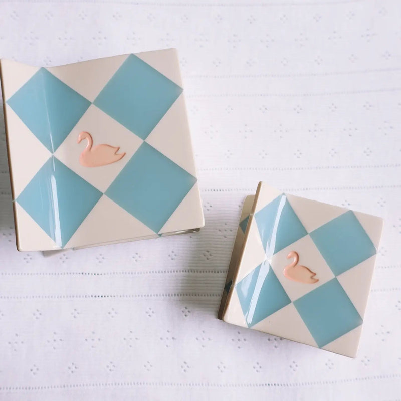 Hair claw with white and light blue patchwork with a rose gold swan in the middle