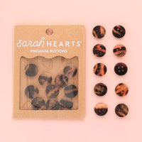 Packaged set of tortoiseshell patterned buttons with 'Sarah Hearts' branding on a pink background.