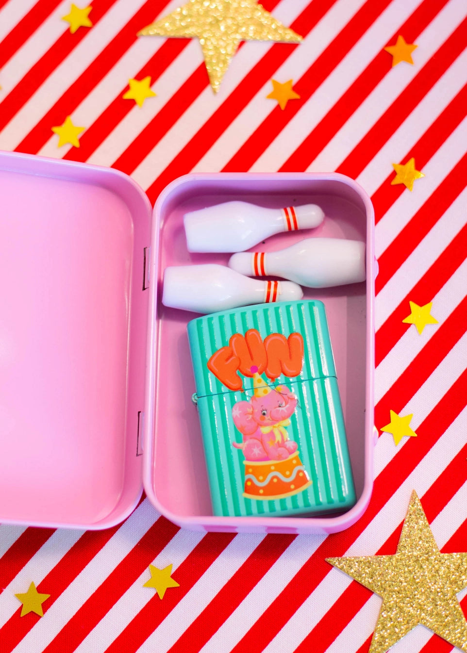 Pink container with a cartoon character lighter on a red and white striped background with gold stars.