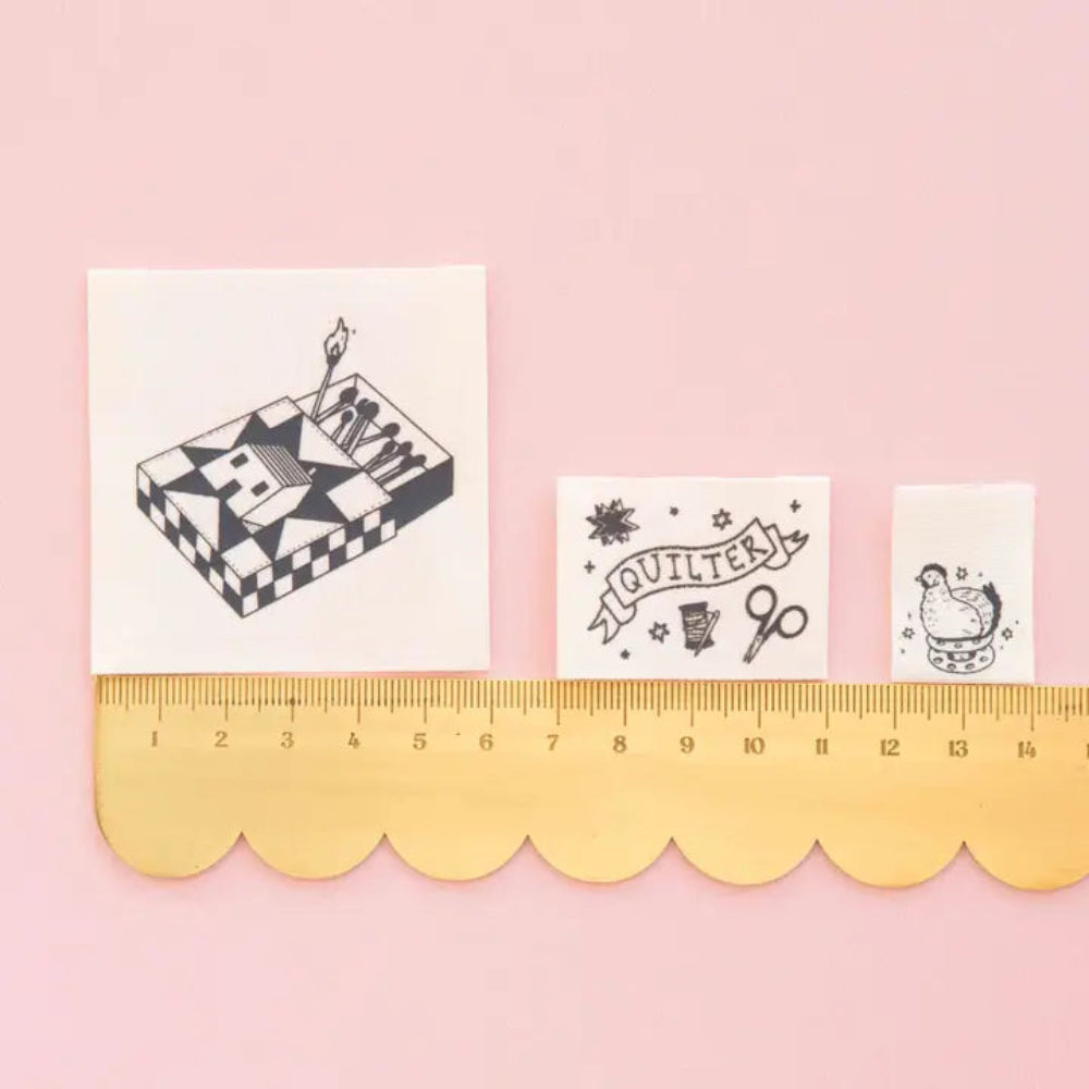 Different labels on a scalloped edge ruler against a pink background. 