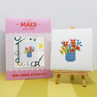 Make Arcade mini cross stitch kit with a completed cross stitch of flowers on a white background