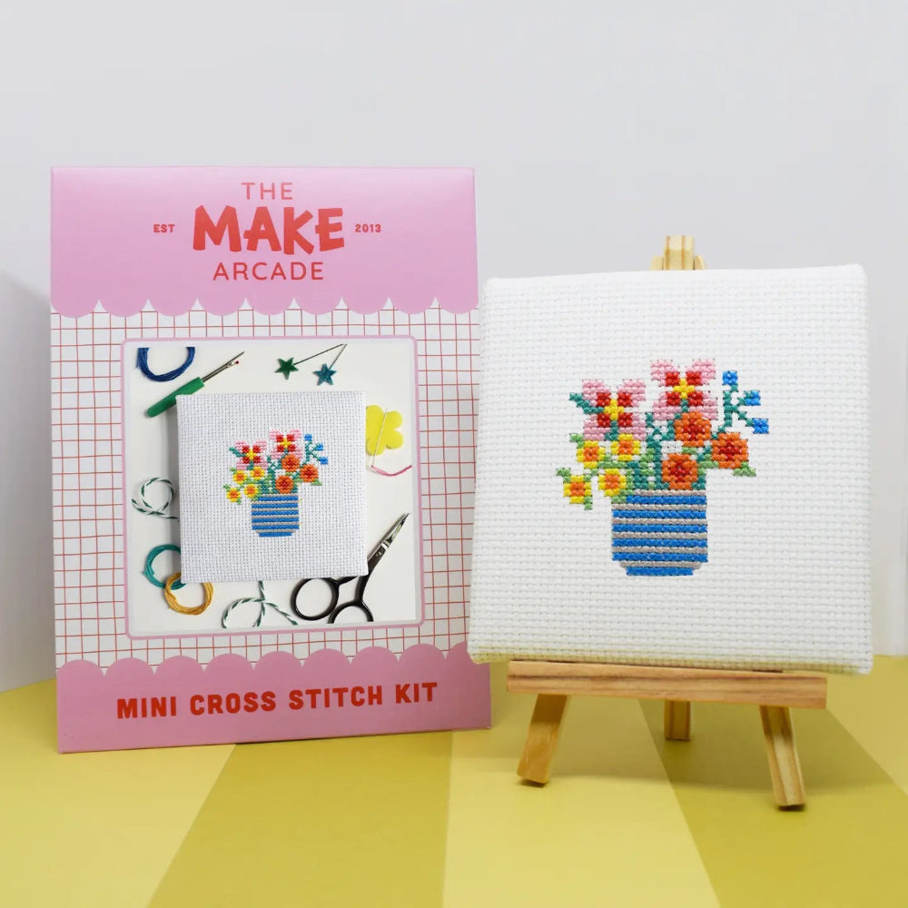 Make Arcade mini cross stitch kit with a completed cross stitch of flowers on a white background