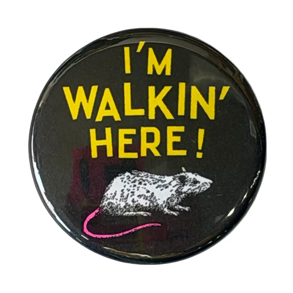 A black button with a rat illustration on the bottom and yellow text that reads " I'm Walkin' Here" against a white background