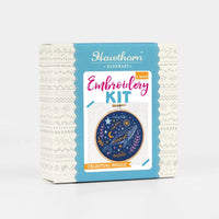 Embroidery kit packaging with celestial design on a white background