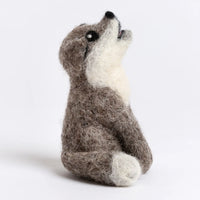 Felted toy resembling a wolf cub on a white background