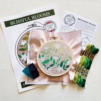 Contents of the Blissful Blooms Beginner Embroidery Kit including floss, a hoop, fabric and more
