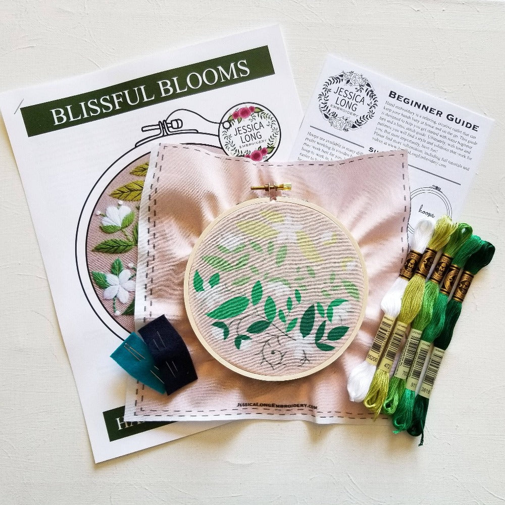 Contents of the Blissful Blooms Beginner Embroidery Kit including floss, a hoop, fabric and more